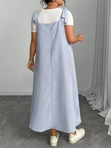 Back view of a loose blue and white vertical striped sundress with bow shoulder straps