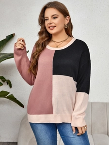 Detail of color block knit sweater featuring pink and beige panels on a textured fabric