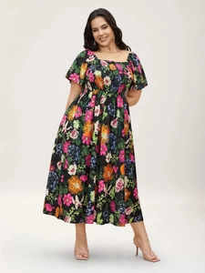 Close-up of smocked waist detail and colorful floral print on black midi dress