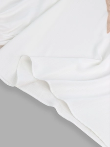 Detail of white V-neck blouse showing vertical pleated fabric texture and light chiffon material