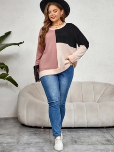 Close-up of color block knit sweater with ribbed cuffs in pink, black, and beige tones