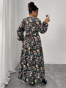 Back view of a long black floral dress featuring high waist tie and a large flowing hem