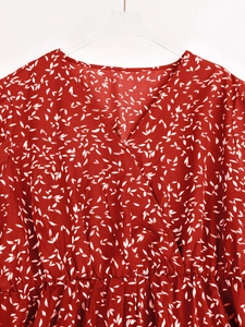 Détail de robe maxi en mousseline rouge à fleurs avec col en V et taille haute élastique