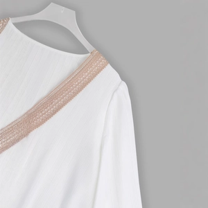 Elegant white V-neck blouse featuring delicate lace trim and textured vertical fabric