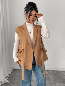 Dettaglio del gilet in pelle scamosciata marrone con revers e lacci laterali regolabili