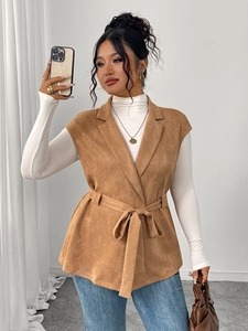 Dettaglio di un gilet scamosciato marrone con grandi revers e cintura per look a strati