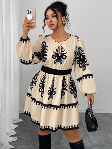 Detail of bohemian floral embroidery and black elastic waist on cream puff sleeve dress