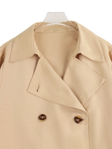 Close-up of lapel collar and dark buttons on a khaki long-sleeve trench coat