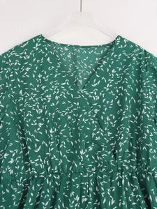 Détail de robe cache-cœur col en V avec motif floral vert forêt et taille haute élastique