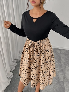 Detail of round neckline with teardrop cutout on black long sleeve patchwork dress