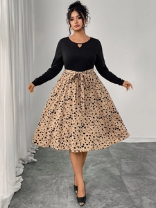Detail of long-sleeved dress with teardrop neckline, leopard print skirt and bow belt