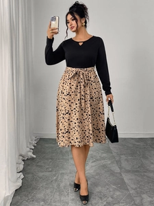 Detail of long sleeve dress featuring leopard print skirt and waist tie decoration