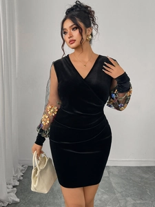 Detail of sheer mesh sleeves with floral embroidery on a black velvet V-neck dress