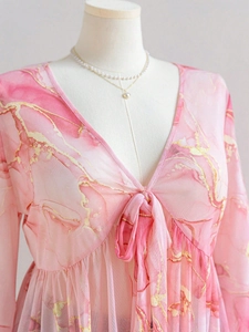 Detail of pink marble print mesh top with V-neck tie and elegant gold glitter texture