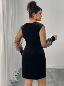 Detail of floral embroidery on sheer mesh sleeves of the black velvet dress