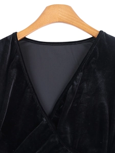 Detail of V-neck neckline with cross-wrap design on black velvet long sleeve dress