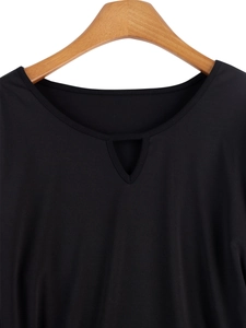 Detail of crew neckline with central V-shaped cutout on a black dress in knit fabric
