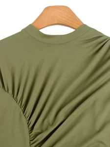 Detailed close-up of olive green round neck dress with ruching and fine stitching