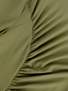 Detailed macro view of olive green ruched fabric on high waist bodycon dress
