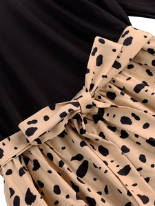 Detail of waist stitching with black fabric and Dalmatian print bow tie decoration