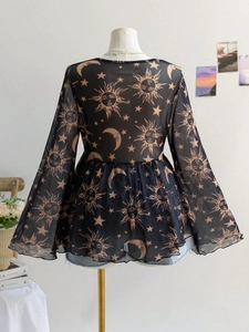 Detailed view of sheer mesh top featuring sun moon star print and flared sleeves