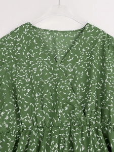 Vue détaillée d'une robe fleurie verte avec col en V, taille élastique et motif feuilles