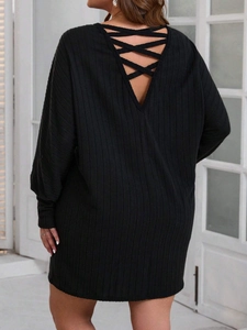 Elegant black knit mini dress featuring long sleeves and a stylish crisscross backless design
