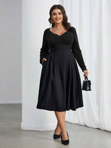 Elegante completo taglie forti con top nero a maniche lunghe e gonna a pieghe