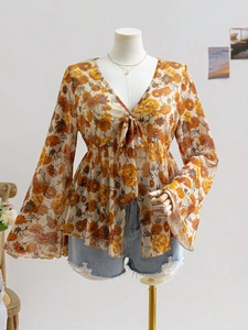 Detail shot of the V-neck lace-up floral top with elegant bell sleeves and daisy print