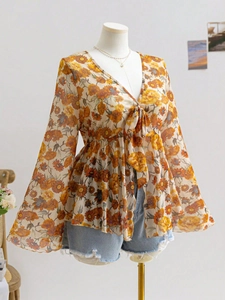 Detail of V-neck floral chiffon top featuring tie-up bow and elegant bell sleeves