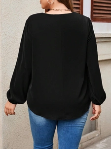 Plus size minimalist black V-neck top for women featuring a long sleeve curved hem back view