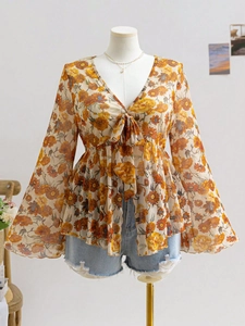 Detail view of floral chiffon top featuring V-neckline, bow tie and elegant flare sleeves