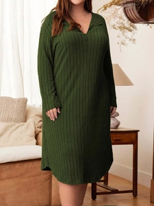 Plus size dark green ribbed knit V-neck long sleeve dress in a cozy home setting