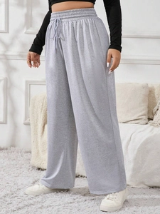 Detail view of high-waist grey wide-leg trousers with drawstring and elastic waistband