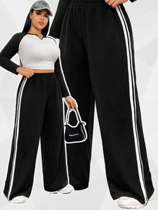 Detail of high-waist wide-leg track pants with side stripes and contrast raglan top