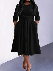 Elegant black mid-length dress with waist tie and pleated hem for a minimalist style