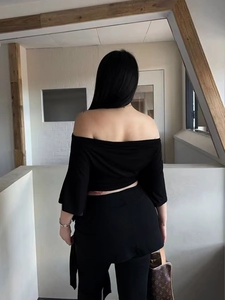 Ensemble sexy noir avec haut à épaules dénudées et pantalon moulant, vue de l'arrière
