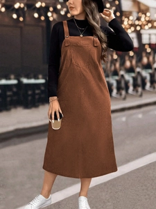 Loose brown corduroy pinafore dress with black turtleneck for a casual autumn style