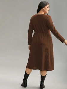 Brown long-sleeve knit midi dress with V-neck and high waist viewed from a back-side angle