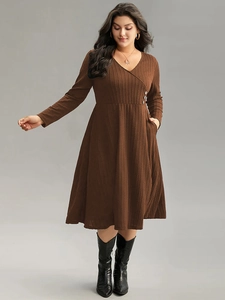 Detail view of coffee-colored V-neck dress with knit texture and side waist buttons