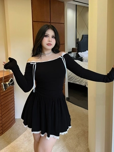 Black off-shoulder dress with white lace trim and bow details on an indoor model