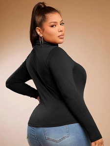 Slim fit black turtleneck long sleeve top for women paired with jeans in a profile view