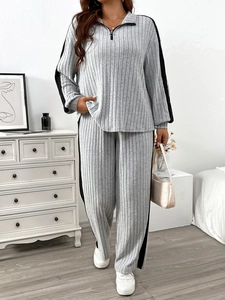 Detail of light gray ribbed loungewear set showing half-zip top and black side stripes