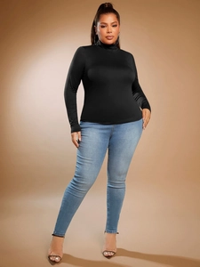 Slim fit black turtleneck long sleeve shirt paired with light blue jeans for women