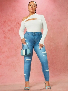 Dettaglio body bianco monospalla abbinato a pantaloni in denim strappati per donna