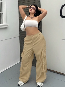 Detail der khakifarbenen High-Waist Cargo-Hose mit mehreren Taschen und Dekorbändern