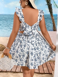 Back view of summer floral midi dress with open back and large bow tie detail on beach