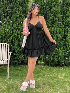 Robe élégante noire à col en V avec fines bretelles, taille haute et ourlet à volants
