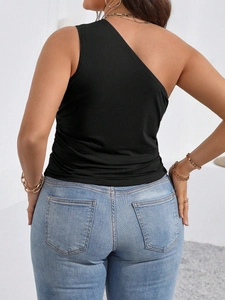 Débardeur noir asymétrique moulant pour femme avec jean et bijoux dorés élégants