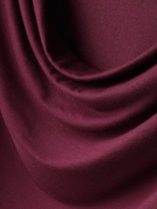 Macro view of the soft burgundy fabric texture showing elegant drapes and pleated details